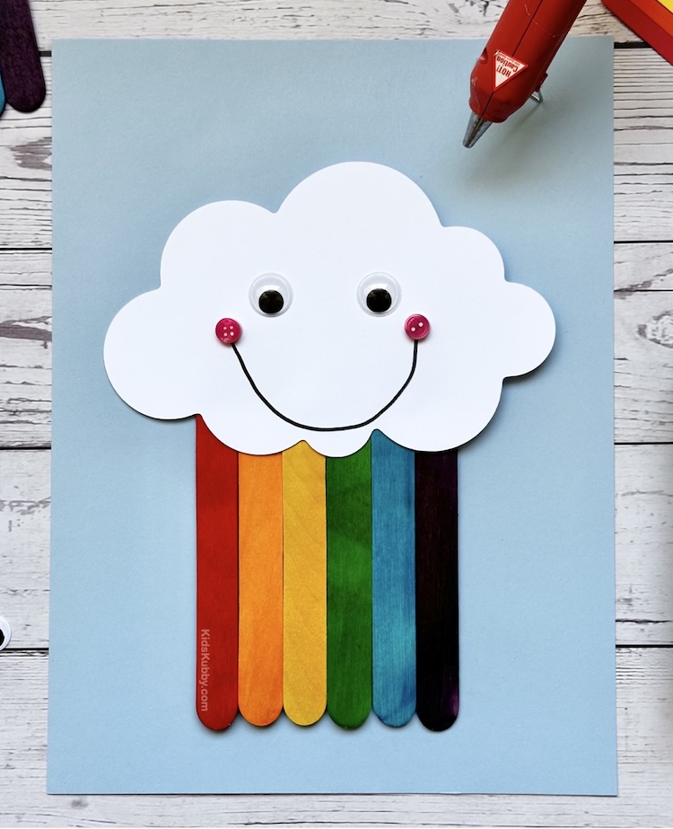 how to make popsicle stick rainbows with just a few cheap supplies found at home. This easy 5 minute craft idea is perfect for kids. Add a ribbon and hang this bright and cheery craft on your walls, doors, or gift to a friend. 