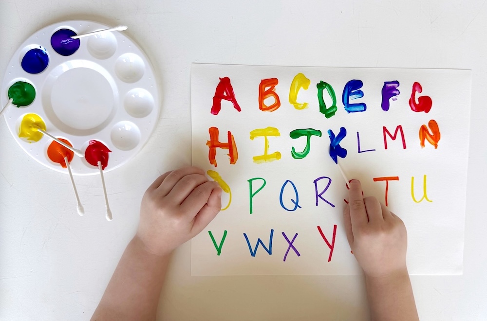 A learning game and art project all in one! Your preschoolers are going to love this letter tracing project using q tips, colorful paint, and paper.